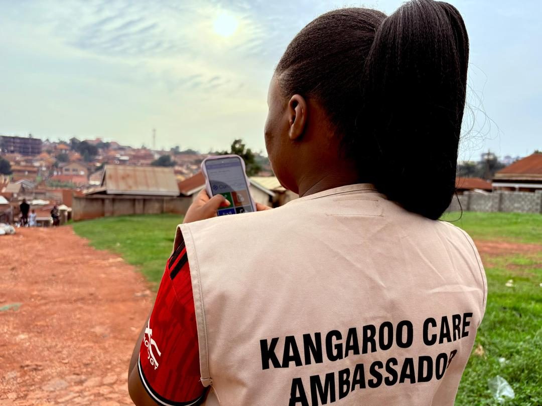 Nama Wellness Center Frontline Worker conducting a Kangaroo Mother Care home visit with a mother and newborn in Mukono District, Uganda
